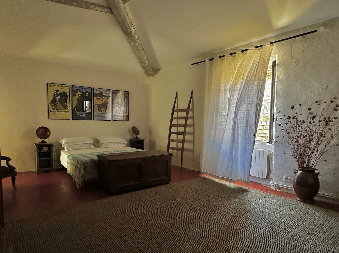 Chambre claire, lit face à la fenêtre, poutres apparentes