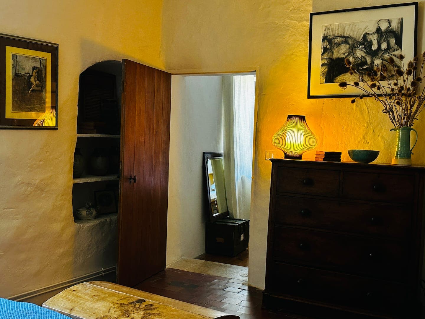 Chambre aux murs ocre et commode ancienne