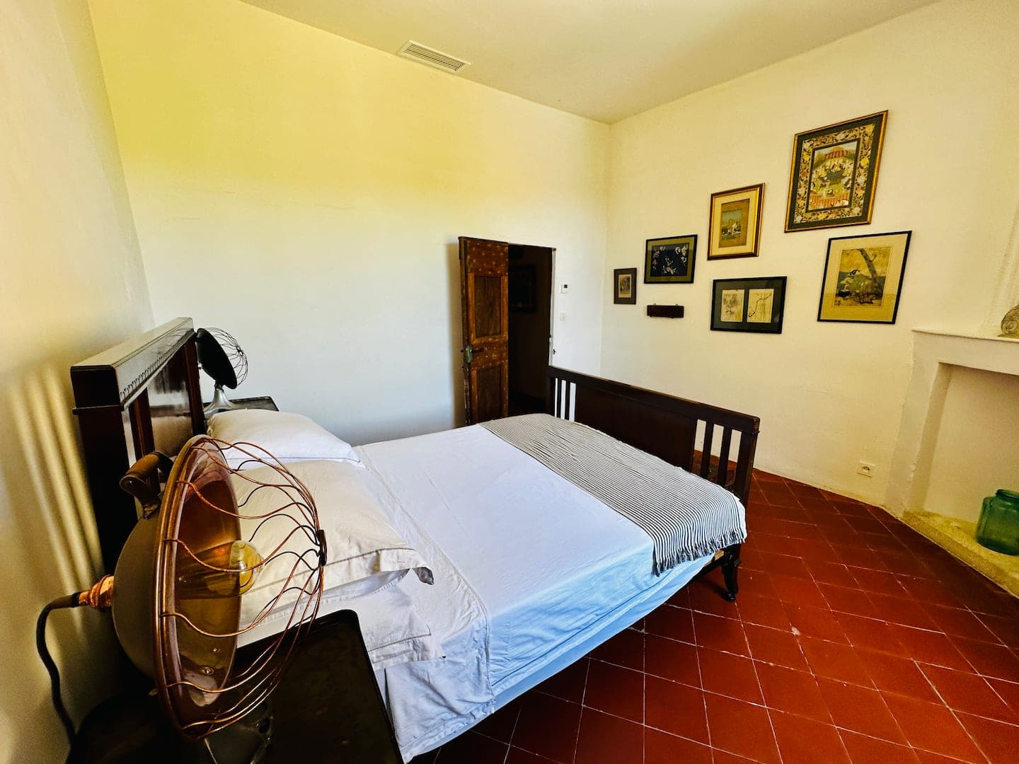 Chambre aux murs de cadres anciens, sol en tomettes