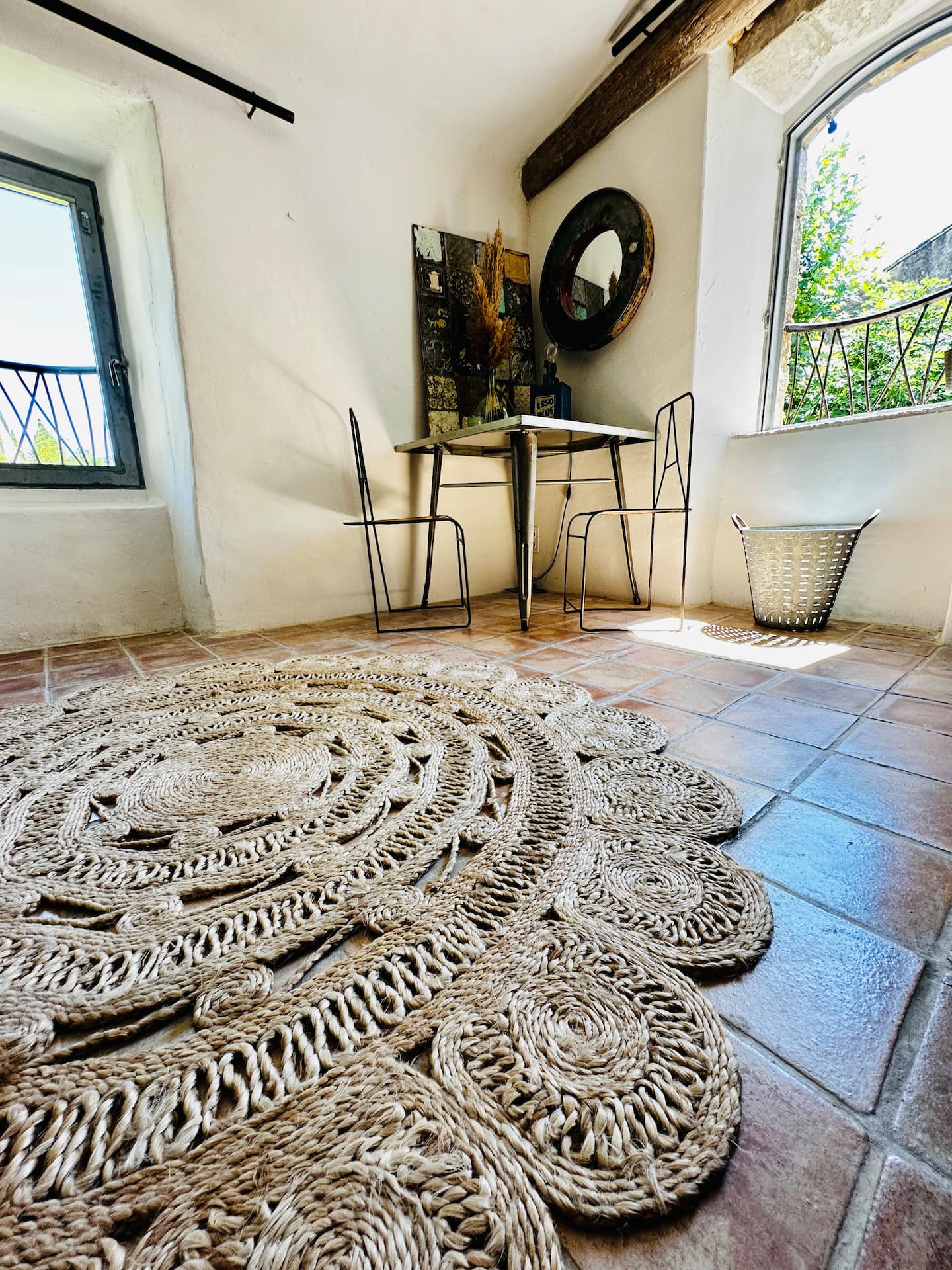 Table ronde et tapis tressé près de la fenêtre