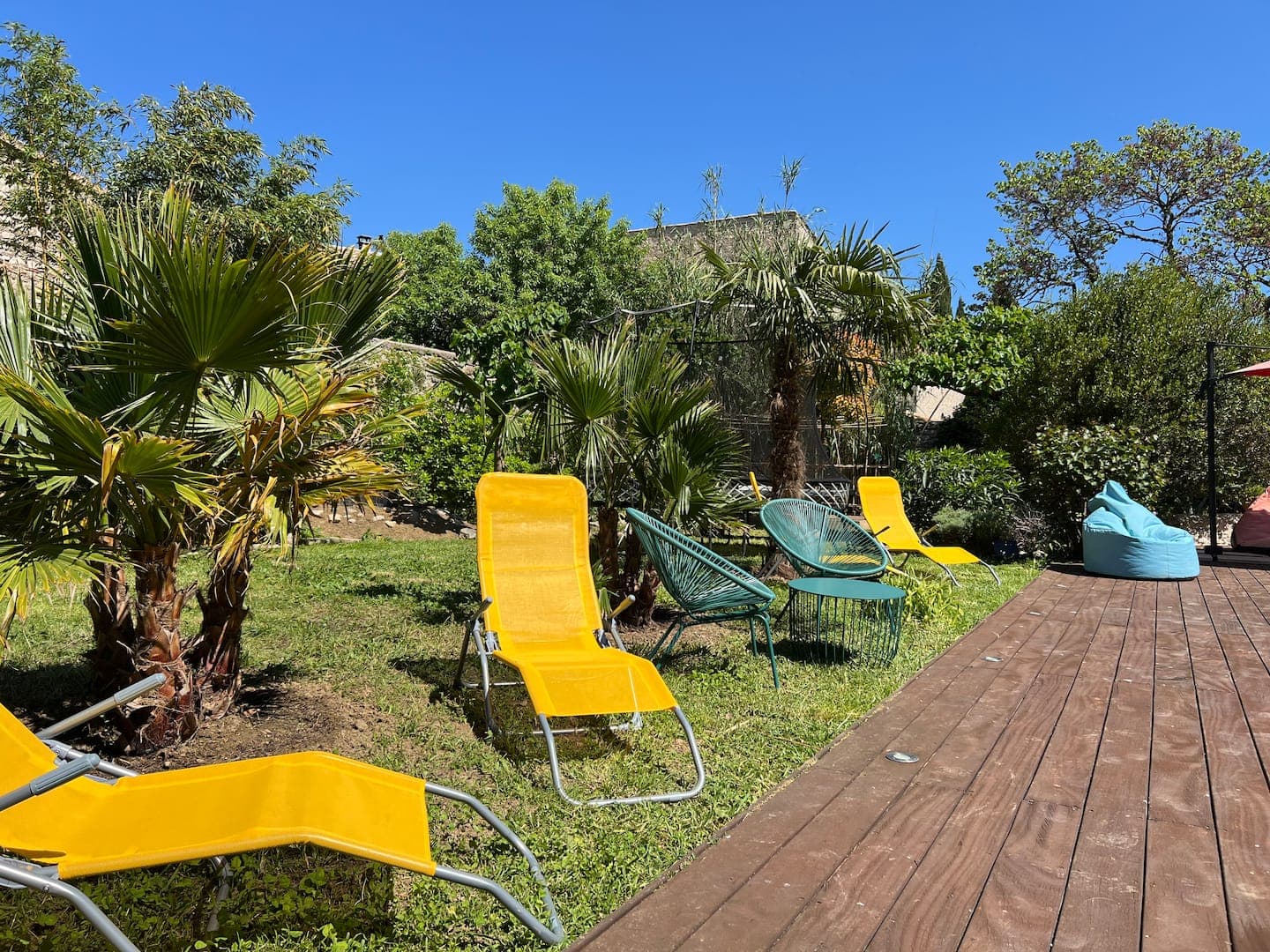 Transats jaunes sur la pelouse et la terrasse en bois