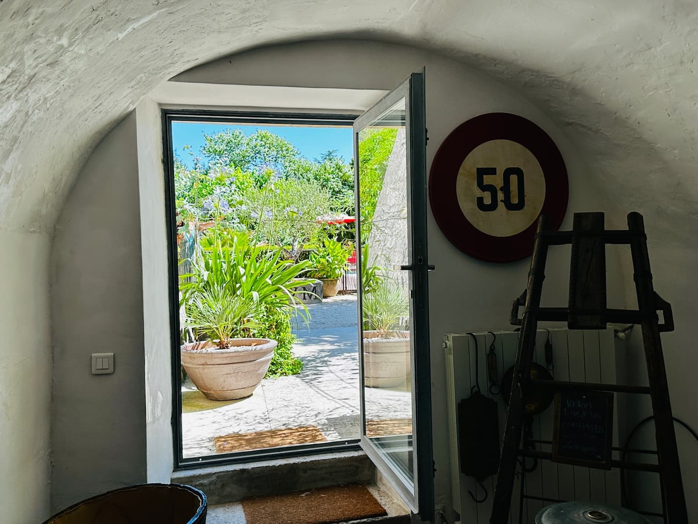 Porte ouverte sur la cour depuis le passage voûté