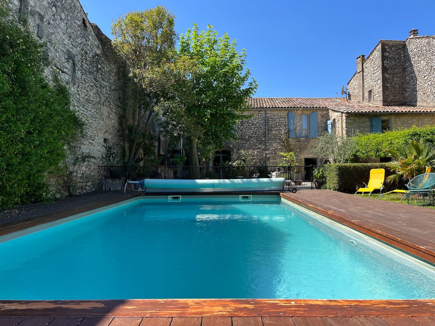 La piscine longée par le mur en pierre du village