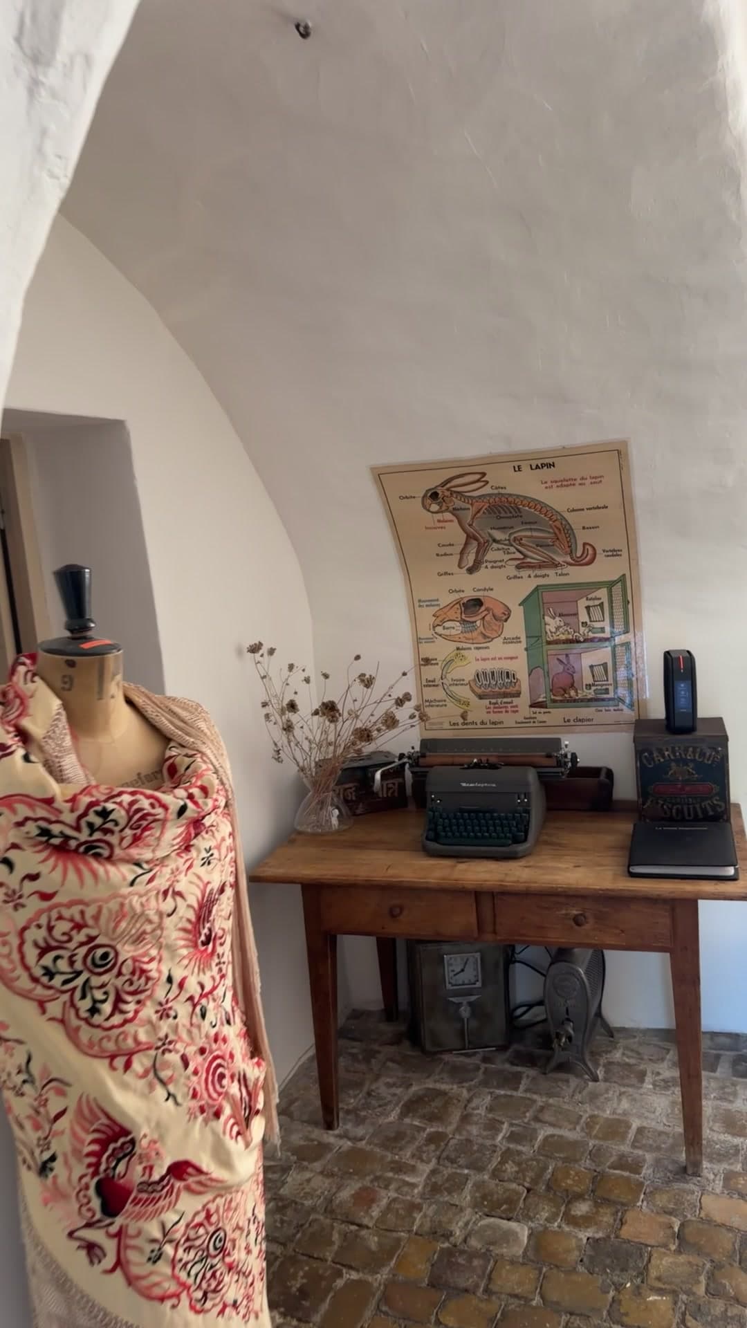 Coin bureau sous la voûte : mannequin drapé, machine à écrire, planche anatomique au mur